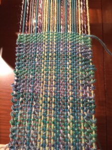 On the rigid heddle loom, I have stash leftovers on the warp, and am using a sparkly worsted weight for the warp.  This is a narrow band which I have plans to ruffle and sew around a shawl.  It's playtime, so we will see what happens!!