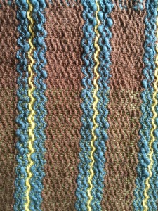 Striped Cotlin warp, except the Blue which is an unknown boucle. Using Reverse twill pattern, which gives a zig zag impression with the stripes. Cool.